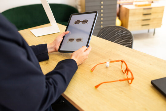 Person browsing glasses selection on a tablet