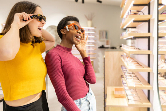 Friends trying on sunglasses at an optical store