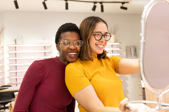 Friends trying on glasses in an optical store