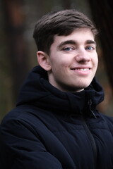Fototapeta premium Male in black winter jacket. Smiling young guy
