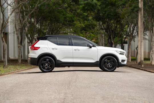 White Volvo XC40 side profile view, Compact luxury SUV parked on tree lined road