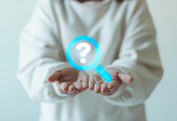 Search and information concept. Magnifying glass and question mark icon over woman open hands, research, support, root cause analysis, problem solving, FAQ, customer service, online help assistance.