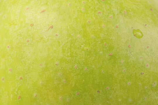 Green apple texture as a background macro photo.