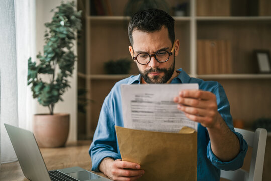 Man reading important documents at home office feeling stressed