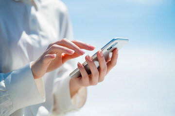 スマホを操作する女性の手元 Woman's hand operating a cell phone Generative AI