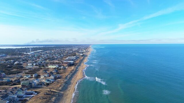 Kill Devil Hills, North Carolina, aerial cinematic video of the Atlantic coastline featuring sandy beaches, vacation homes, and the expansive Outer Banks landscape.