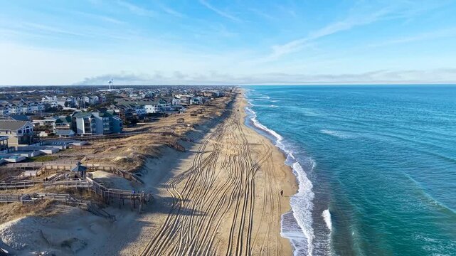 Kill Devil Hills, North Carolina, aerial cinematic video of the Atlantic coastline featuring sandy beaches, vacation homes, and the expansive Outer Banks landscape.