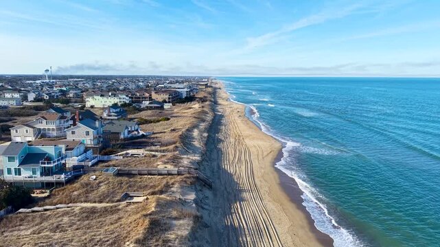 Kill Devil Hills, North Carolina, aerial cinematic video of the Atlantic coastline featuring sandy beaches, vacation homes, and the expansive Outer Banks landscape.