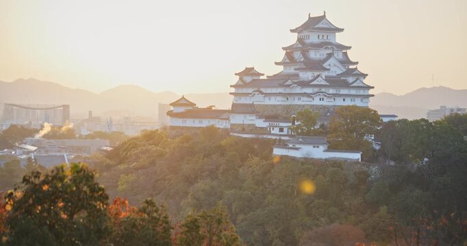 Beautiful, cinematic sunset glow over autumn hills and 16th century Matsumoto castle on hill