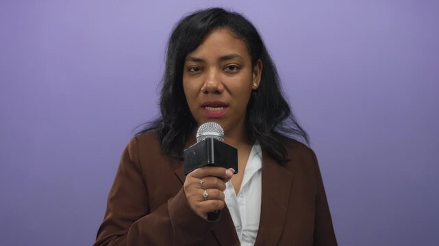 African american woman singing with closed eyes into microphone against purple background in studio; confidence.