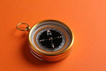 One compass on orange background, closeup view © New Africa