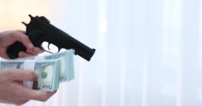 Woman giving money to dangerous criminal with gun indoors, closeup. Armed robbery