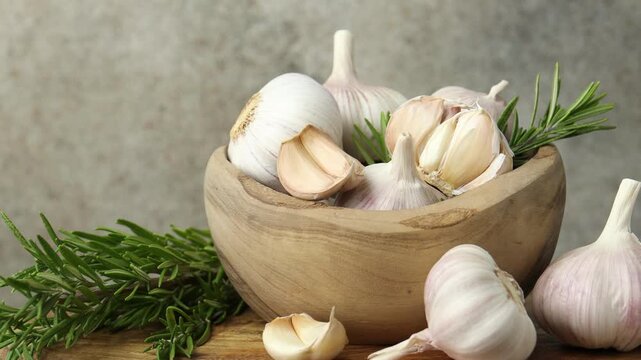 Fresh garlic and rosemary on wooden table, spinning