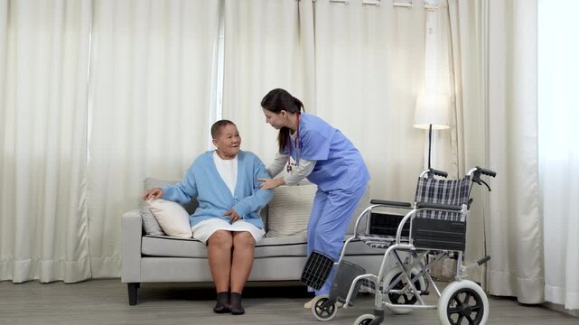 Female caregiver, aged care support helping mature women patient to recover injured leg, physiotherapy, take wheelchair for patient.