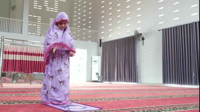 Title: A Muslim girl is praying in Islam

