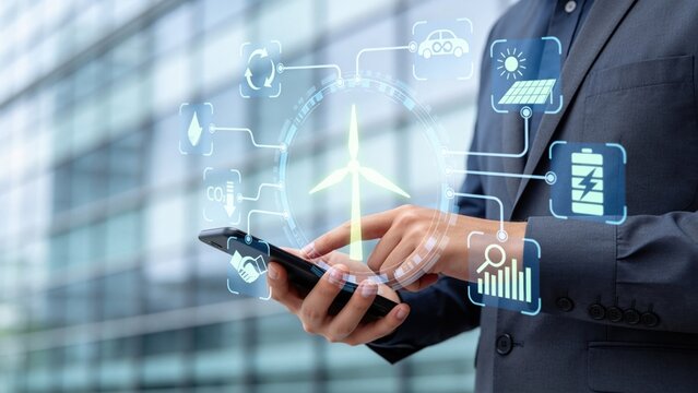 Business executive using smartphone with renewable energy management interface,wind turbine and battery storage icons for sustainability strategy,green technology and smart mobility concept