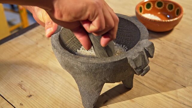 Person curing a traditional mexican molcajete with rice