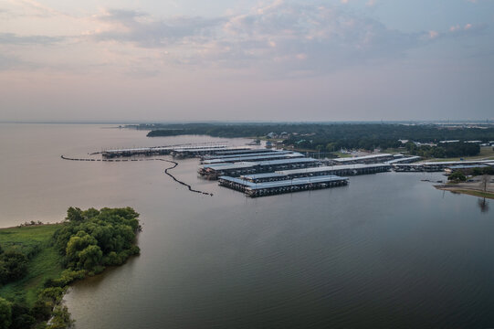 Aerial Drone View of Boat Docks on Large Lake With Green Coastline and Purple Sunset Cloudy Sky in Lewisville, Texas