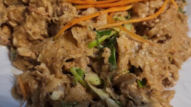 Kothu roti with carrots and spices served on plate.