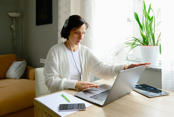 Naklejka premium A business professional woman works remotely from home using electronic gadgets and devices.