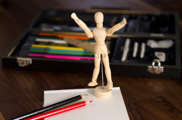 Artist Wood Mannequin with Crayons Kit on Wood Table