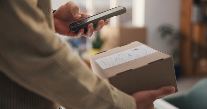 Person, hands and phone with box for scan, logistics or delivery tracking confirmation in home. User, package or label with mobile smartphone scanner for courier service, distribution or supply chain
