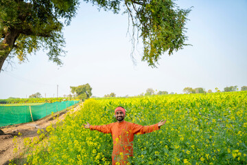 indian farmer standing at mustard agriculture field © Niks Ads