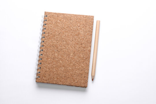 Cork cover spiral notebook with wooden pencil on white background. Eco concept