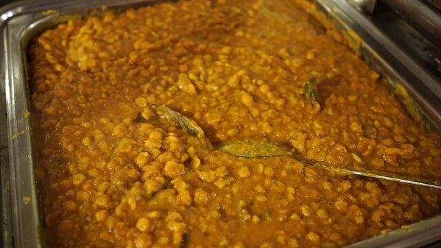 Traditional Bengali Cholar Dal with fried coconut shavings and aromatic spices, served in a festive wedding-style arrangement.