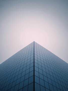 Modern glass skyscraper with sleek architecture and reflective facade towering into the sky with a minimalist design and plenty of natural light