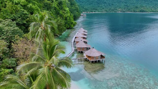 Landscape Stunning Ora Beach with Overwater Cottages in Sawai Saleman, Maluku Tengah, Indonesia. Exotic tropical landscape of Ora Beach located in Sawai Saleman