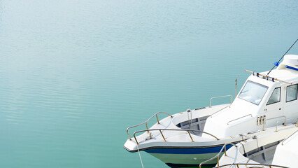 Fototapeta premium High angle view of a white yacht docked on calm turquoise water, minimalist style