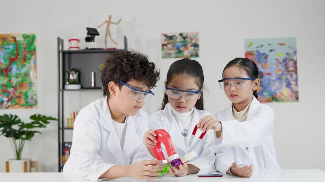 Asian Children in Lab Coats Conducting Science Experiment with Magnets
