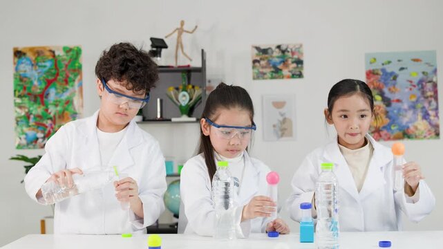 Asian Students in Lab Coats Performing Bernoulli Principle Science Experiment