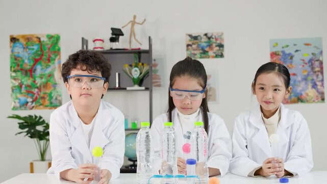 Asian Students in Lab Coats Conduct Bernoulli Principle Science Experiment