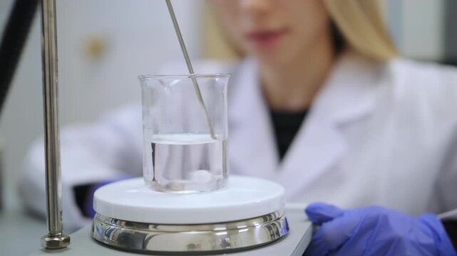 Scientist observing magnetic stirrer during extraction process. Biotechnology, natural products and supplement industry concept.