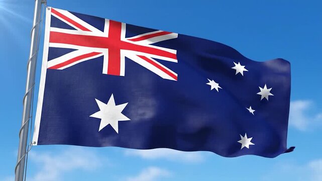 The national flag of Australia proudly waves against a clear blue sky.