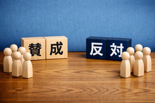 木製ブロックの賛成と反対の文字を前に意見が分かれる人々のイメージ
