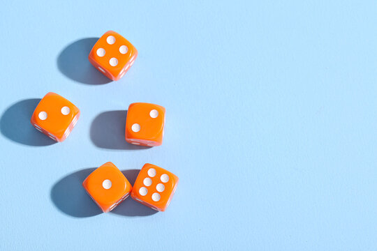 Orange game dices on blue background
