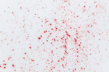 Red drops of blood on white snow as a background