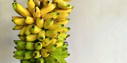 Fresh bunch of ripe yellow and green bananas isolated on white background, showcasing natural texture and tropical harvest. © krustovin
