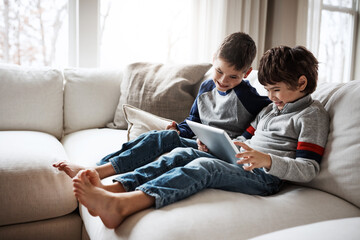 Tablet, reading and relax with children on sofa for education app, support and learning game....