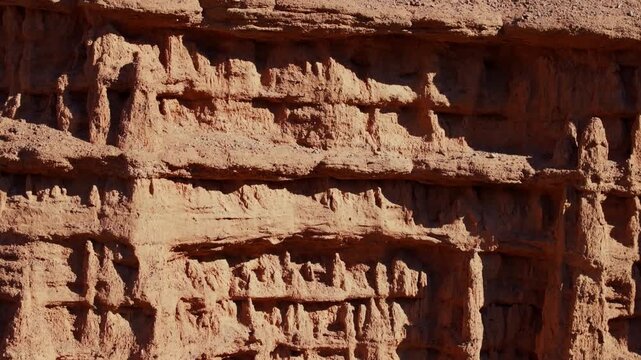 Closeup aerial view of eroded sandstone vertical slope at sunny day in Konorchek Canyon in Kyrgyzstan