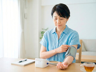 自宅で血圧を測定する女性