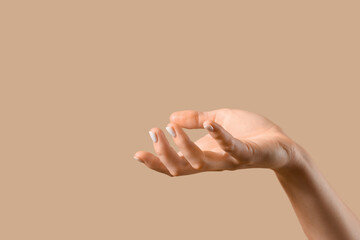 Female hand on beige background