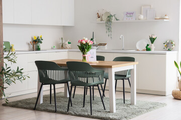 Fototapeta premium Interior of light kitchen decorated for Easter with dining table and counters