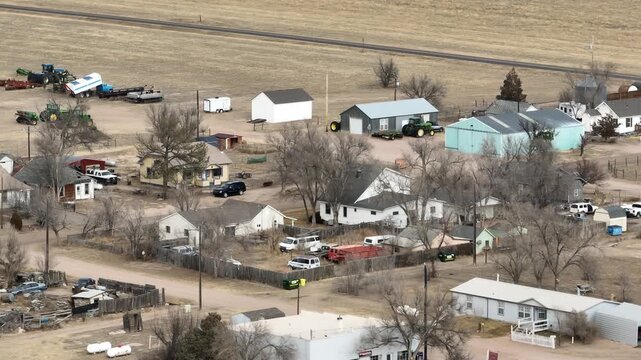 Briggsdale Colorado pan shot over homes and farm equipment.