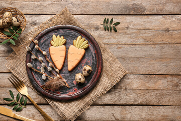 Beautiful table setting with sweet cookies, quail eggs and pussy willow branches on wooden...
