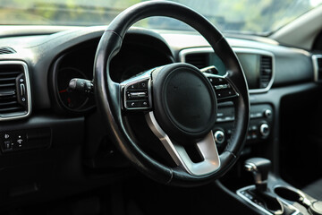 Modern car interior with a focus on the steering wheel and dashboard controls