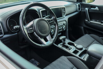 Modern car interior with steering wheel, dashboard, and automatic gear shift